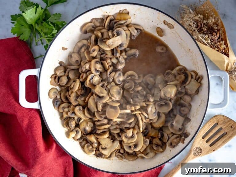 Golden Garlic Mushrooms 24 chopped mushrooms in a white skillet releasing water