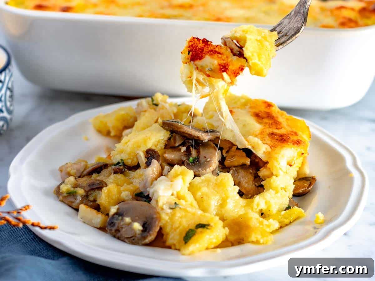 Golden Garlic Mushrooms 4 polenta lasagna portioned on a white plate with a fork