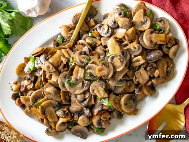 Golden Garlic Mushrooms 27 sauteed mushrooms served with a wooden spoon on a platter
