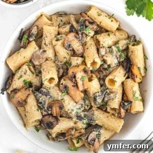 Creamy hummus pasta with Italian sauteed mushrooms, served in a dish.