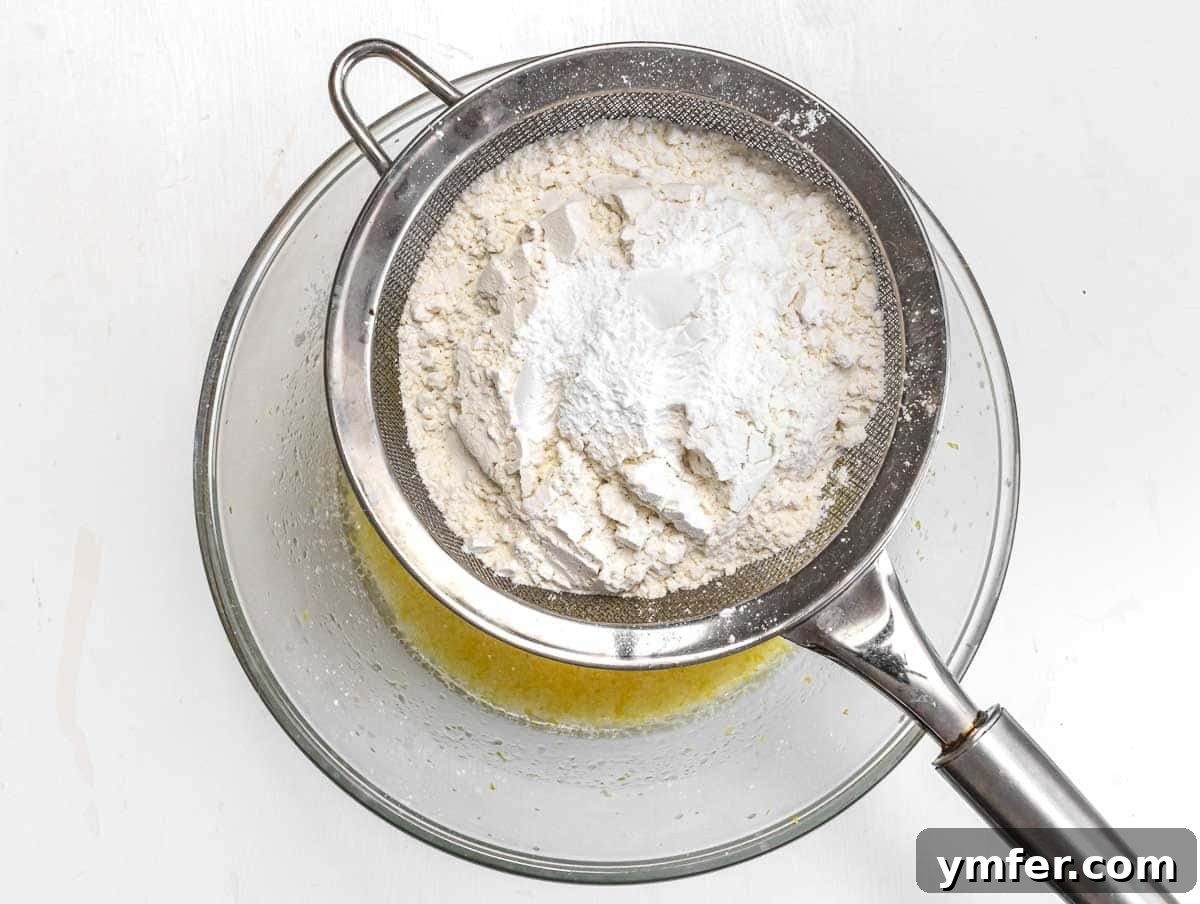 Adding flour and other dry ingredients to the wet muffin batter.