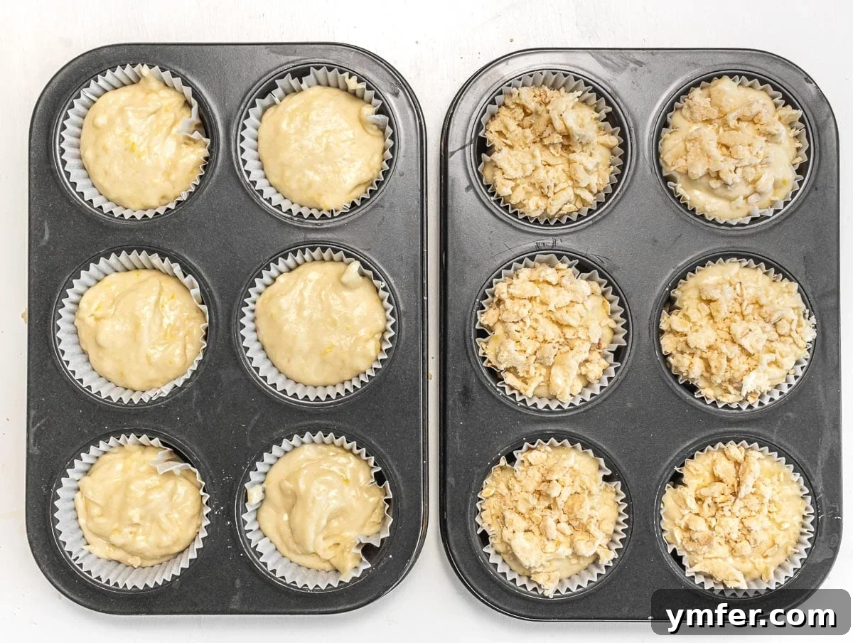 Muffin pan filled with batter, some with streusel topping.