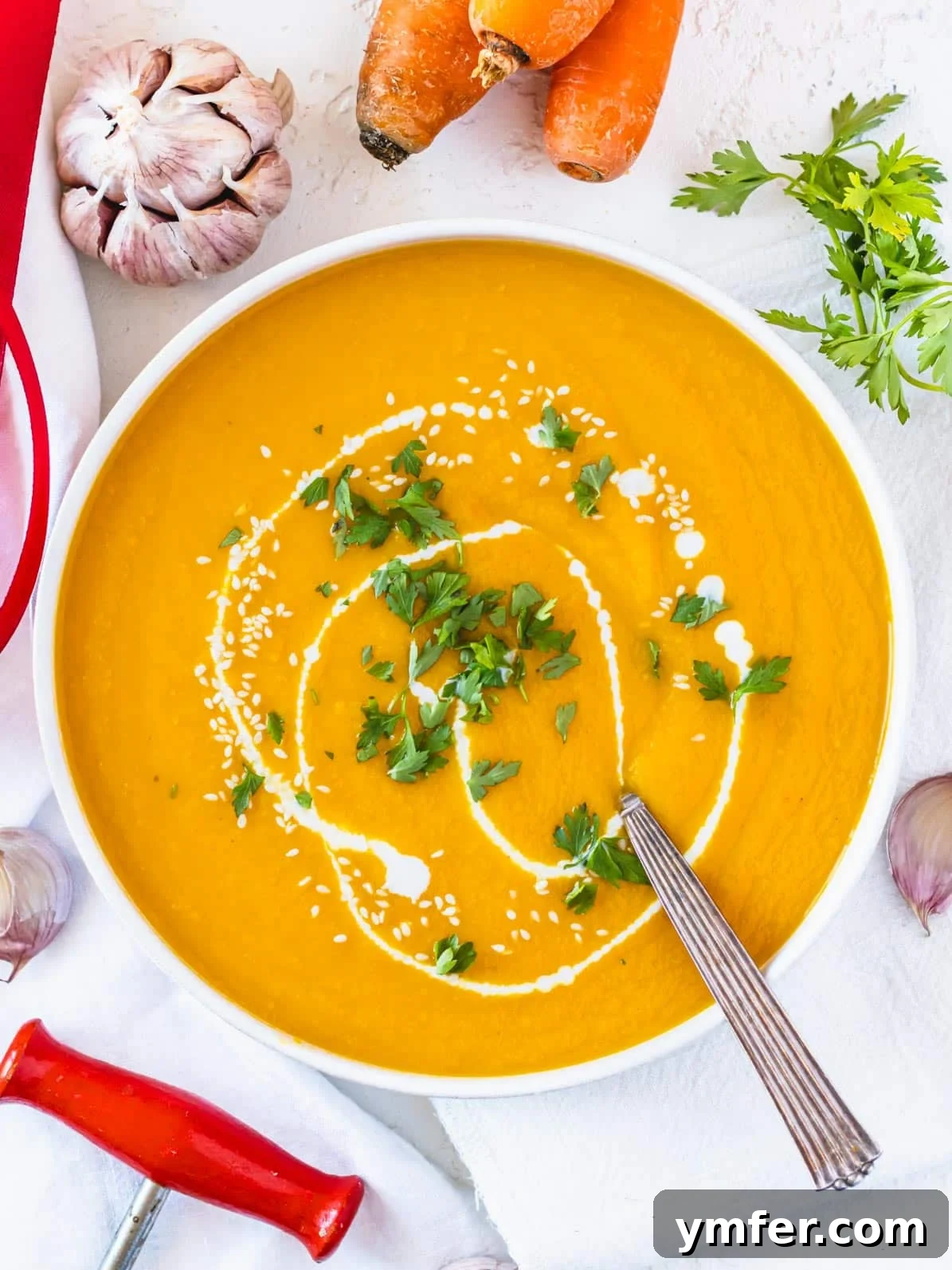 Golden Ginger Carrot Elixir 2 carrot soup in a white bowl with silver spoon