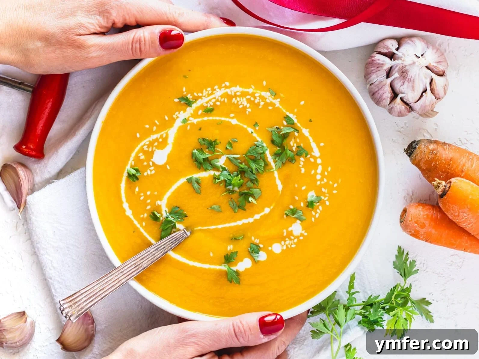 Golden Ginger Carrot Elixir 3 carrot soup in a bowl with hands