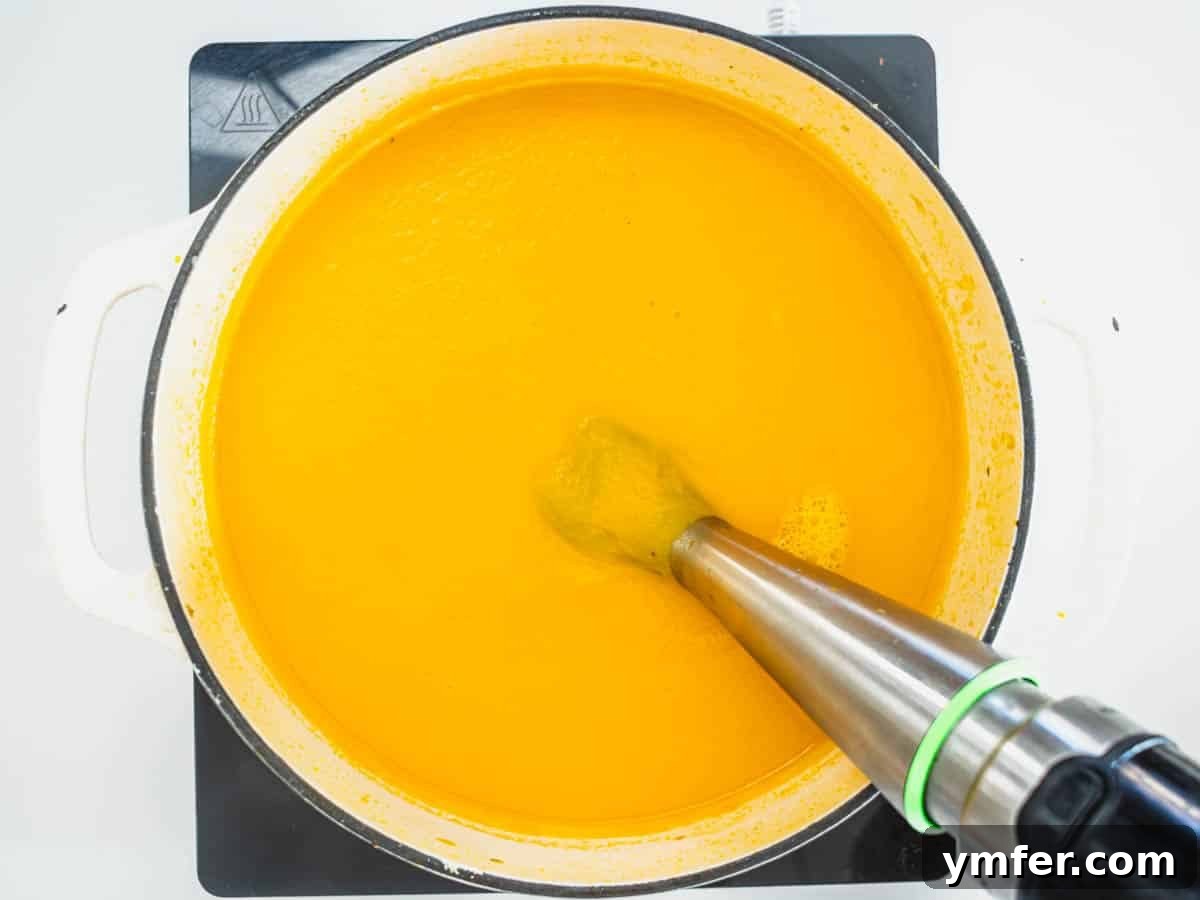 Golden Ginger Carrot Elixir 9 carrot soup in a casserole with a hand mixer
