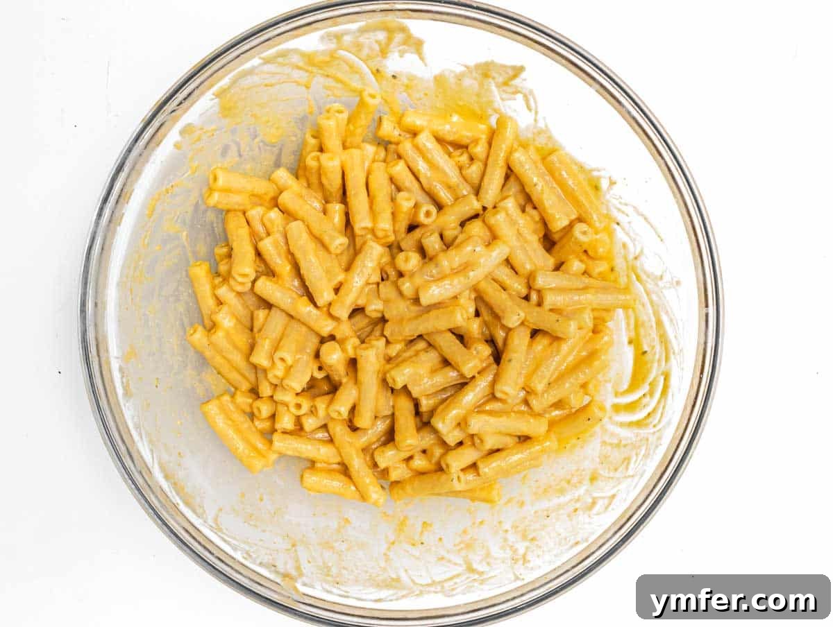 Golden Harvest Pumpkin Pasta 11 Cooked ziti pasta mixed with pumpkin sauce in a large bowl, showing its even coating.