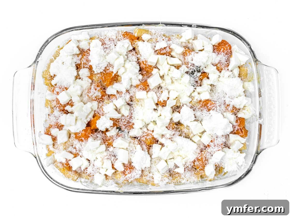Golden Harvest Pumpkin Pasta 14 The pumpkin pasta bake topped with dollops of ricotta, shredded mozzarella, and grated parmesan cheese before baking.