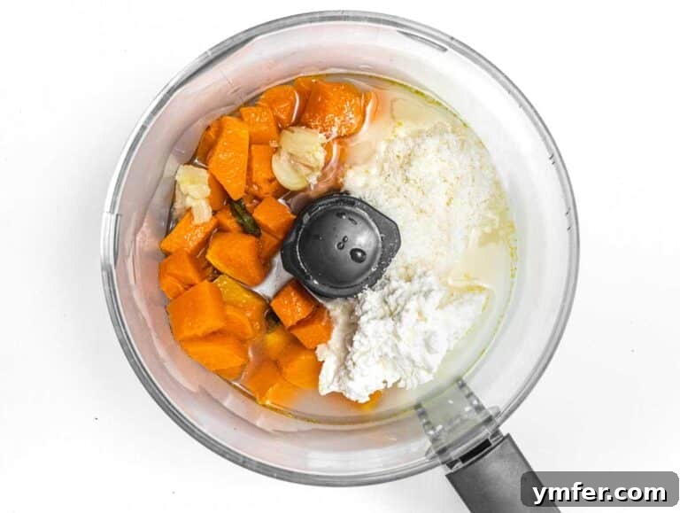 Golden Harvest Pumpkin Pasta 20 Ingredients for the pumpkin sauce, including roasted pumpkin, garlic, sage, ricotta, parmesan, and olive oil, in a food processor.