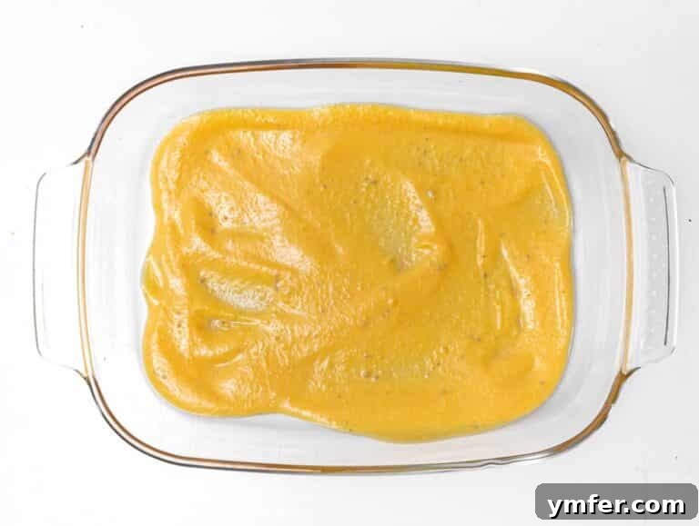 Golden Harvest Pumpkin Pasta 22 A baking pan with a layer of pumpkin ricotta sauce covering the bottom.