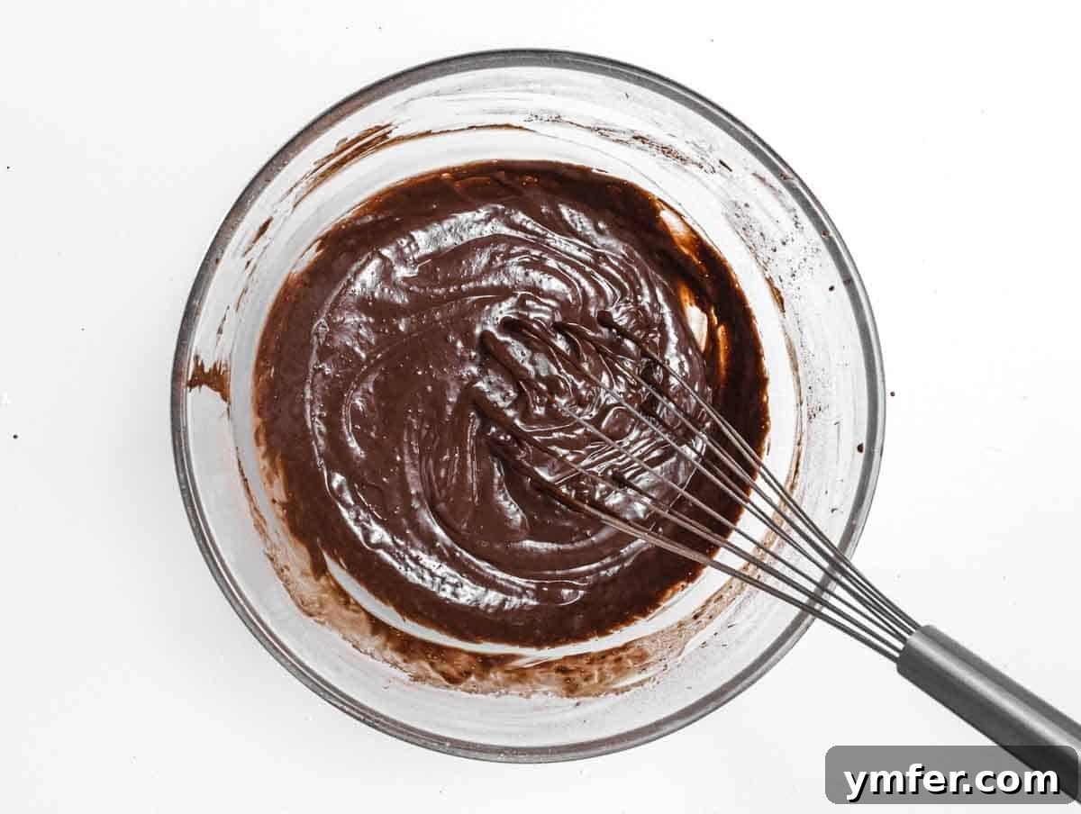 Decadent Chocolate-Coated Doughnuts 7 Whisk and chocolate mix in a glass bowl