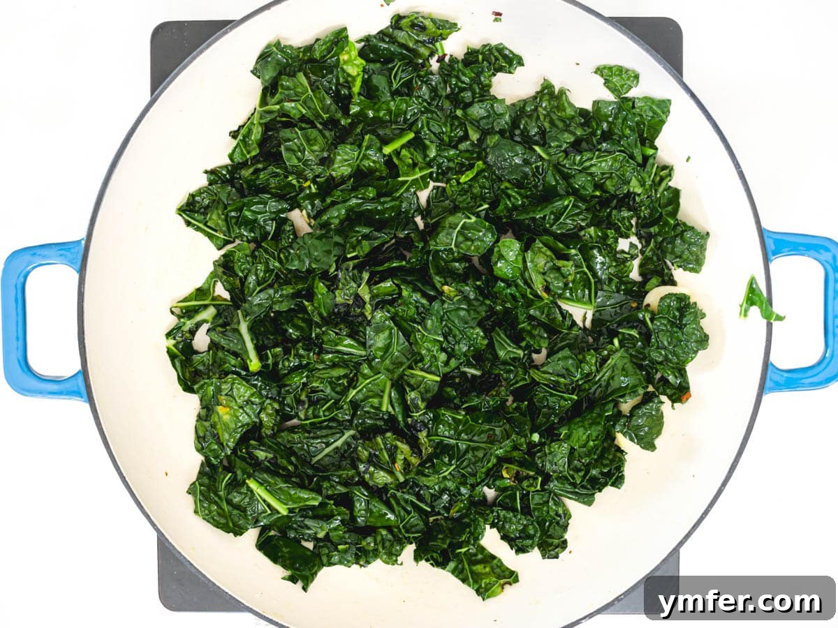 Royal Spire Sweet 9 Kale leaves sautéing in a skillet with garlic and red pepper flakes