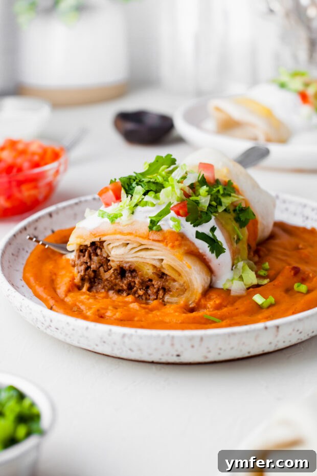 Richly Sauced Burritos 6 Smothered Burrito cut in half to show beef filling.