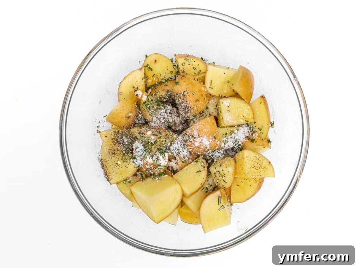 Crispy Air Fryer Potatoes 6 Potatoes in a bowl with herbs