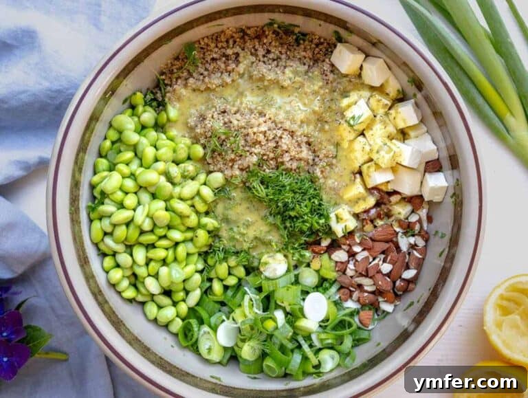 Toasted almonds, chopped dill, scallions, and cooked edamame in the bowl with the kale