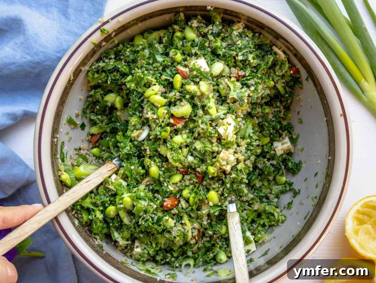 All ingredients for the kale quinoa salad tossed in the bowl with the dressing.