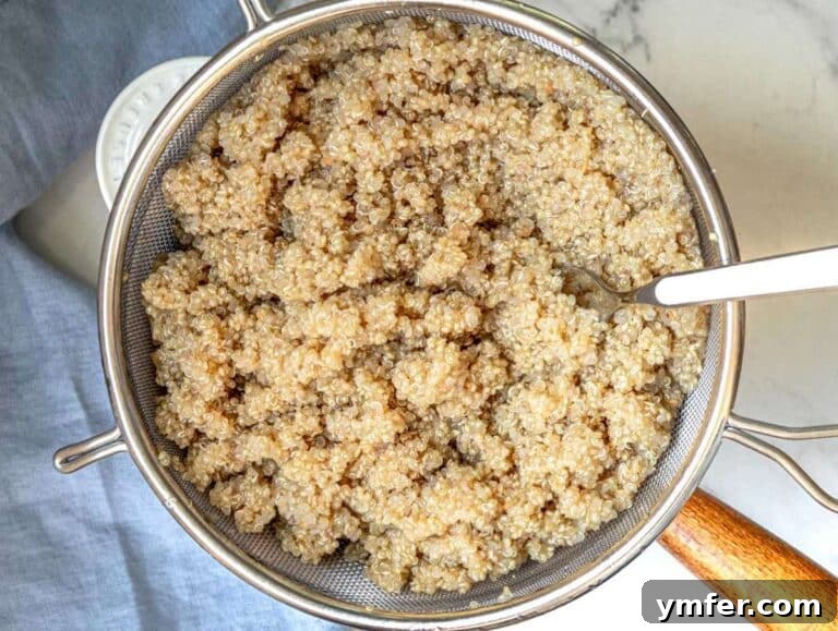 White quinoa cooking in a pot and cooling in a fine mesh strainer, step one for making a heart-healthy kale quinoa salad