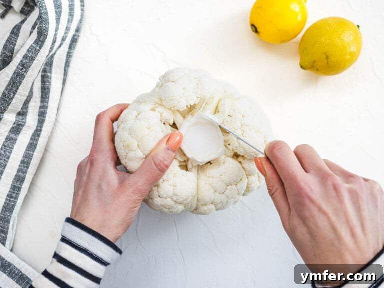 Glorious Whole Roasted Cauliflower 14 hands trimming of head of cauliflower with a pairing knife