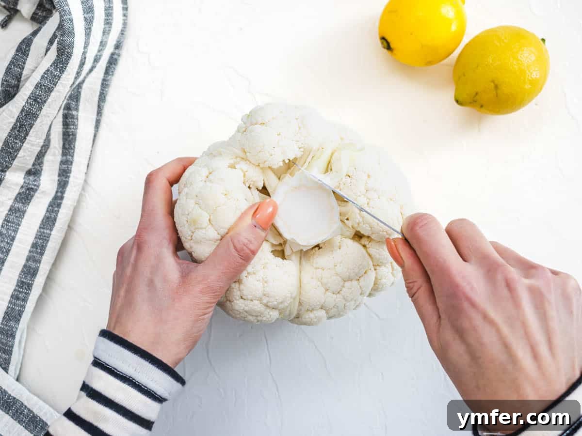 Glorious Whole Roasted Cauliflower 6 hands trimming of head of cauliflower with a pairing knife