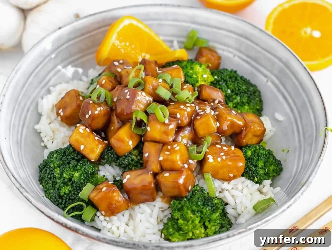 Quick & Delicious: 20 Easy Broccoli Recipes 17 Sticky and savory orange tofu served alongside vibrant green steamed broccoli, creating a balanced and flavorful meal.