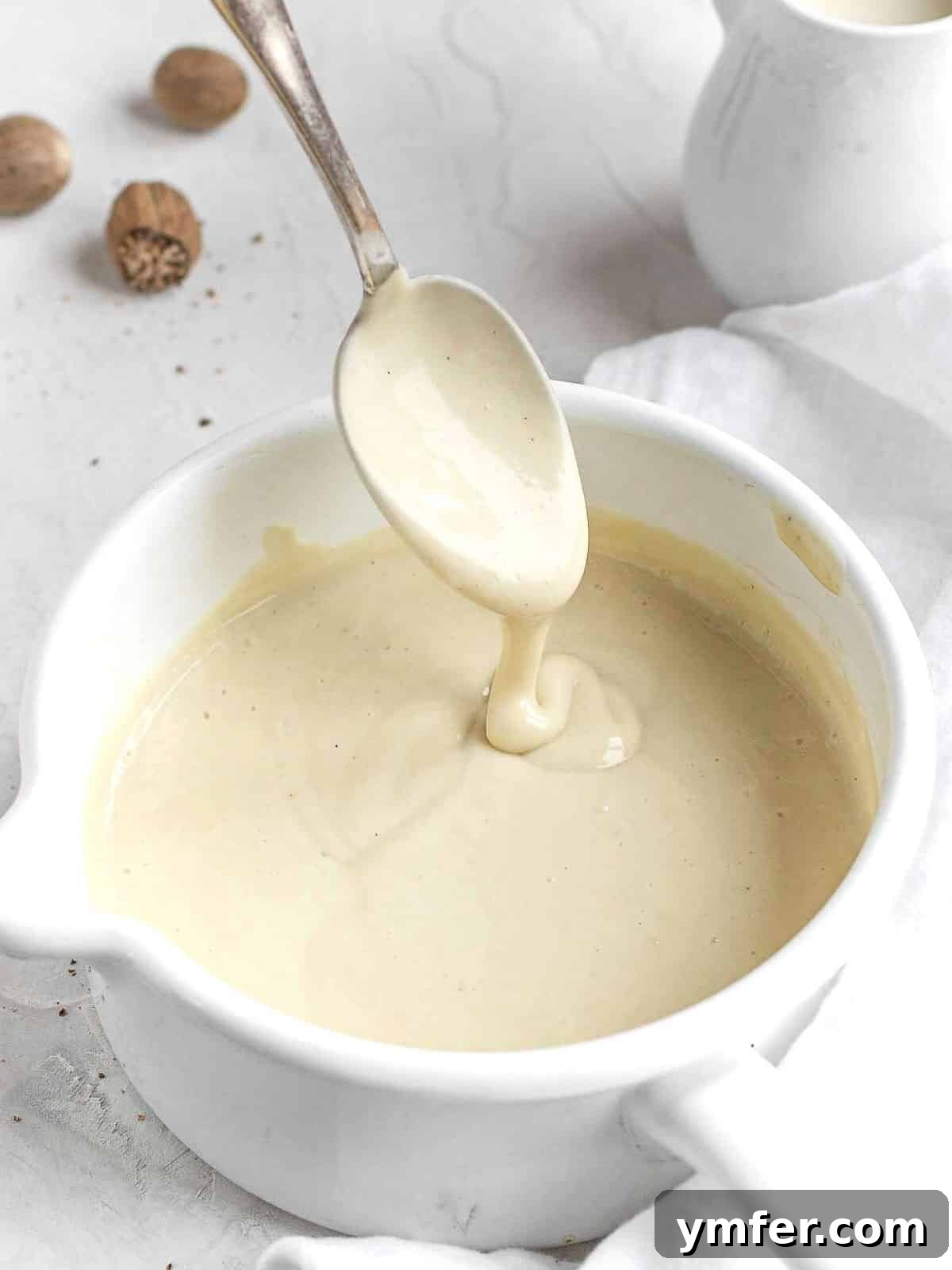 Luscious Vegan Cream Sauce 2 Creamy vegan white sauce in a pristine white pot, ready to be incorporated into various delicious dishes.