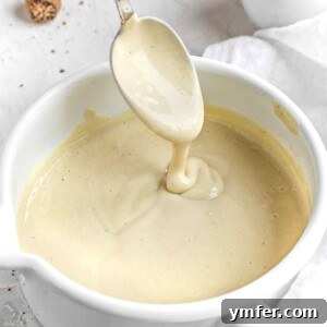 Luscious Vegan Cream Sauce 9 Close-up of freshly made vegan white sauce in a bowl, highlighting its smooth and appealing texture.