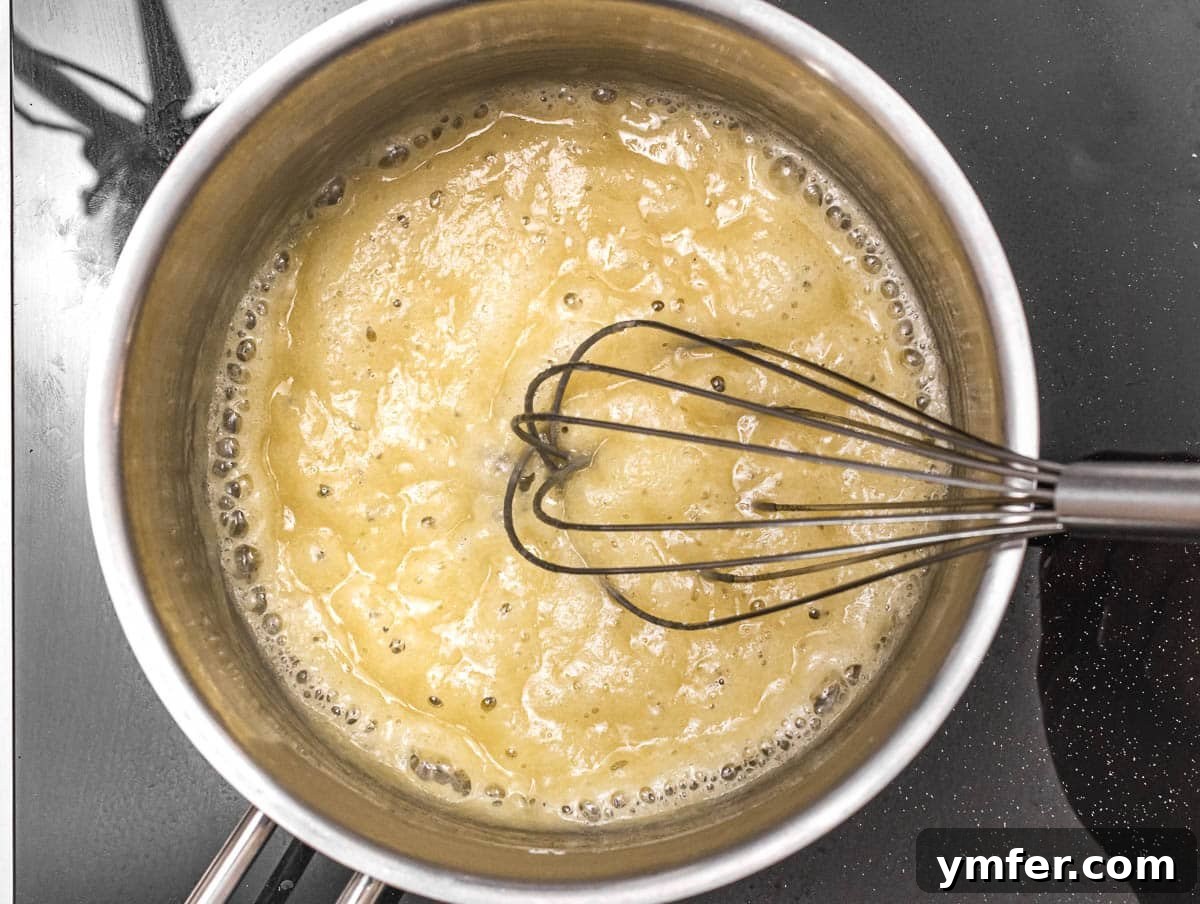Luscious Vegan Cream Sauce 5 Olive oil and flour being whisked together in a saucepan to form a perfect roux for vegan béchamel.