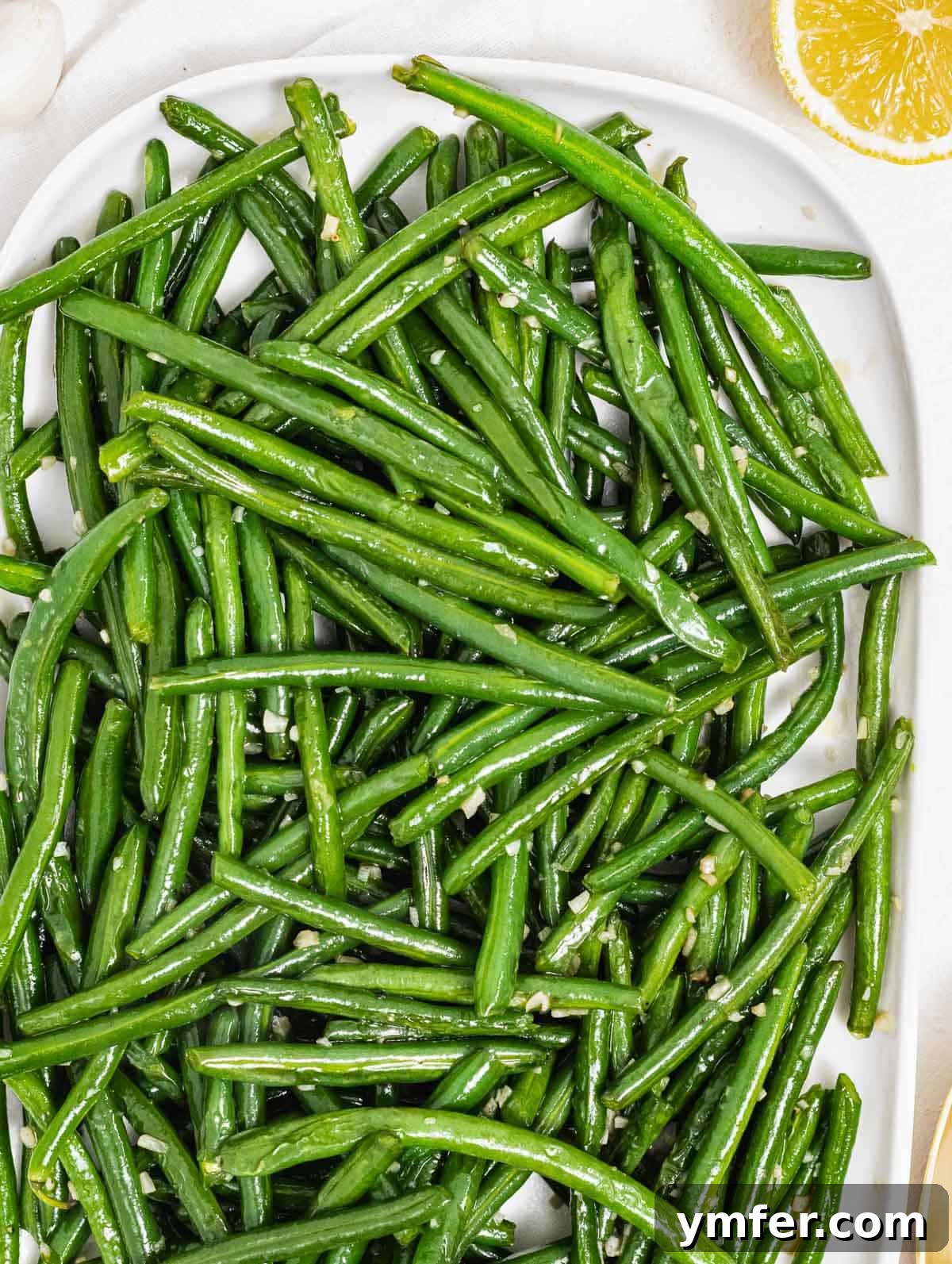 Flavorful Sautéed Green Beans 2 Perfectly Sautéed Green Beans on a white plate, ready to serve