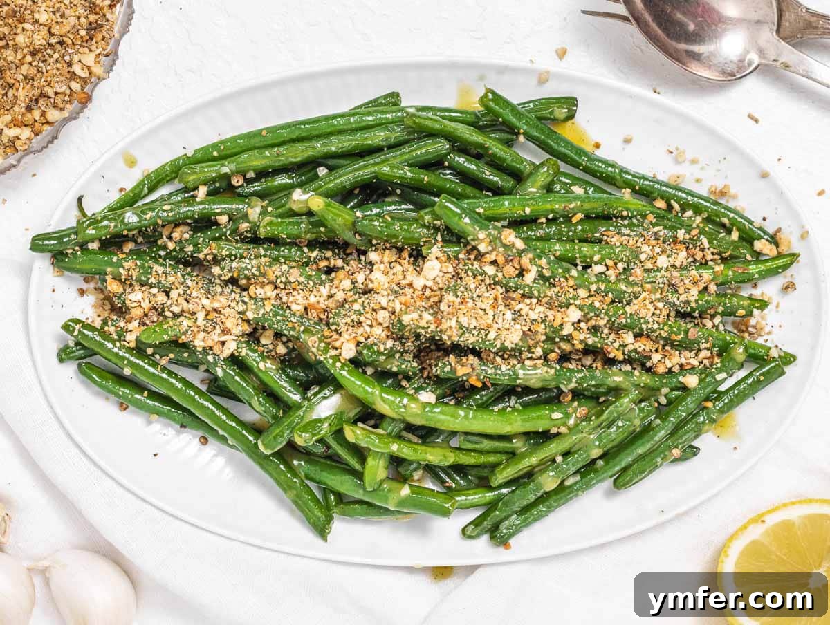 Flavorful Sautéed Green Beans 12 Sautéed green beans generously sprinkled with Dukkah, a flavorful Middle-Eastern nut and spice blend, served on a white plate