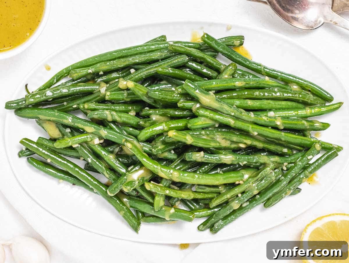 Flavorful Sautéed Green Beans 3 Vibrant Sautéed Green Beans drizzled with a rich honey mustard dressing, artfully arranged on a white serving dish