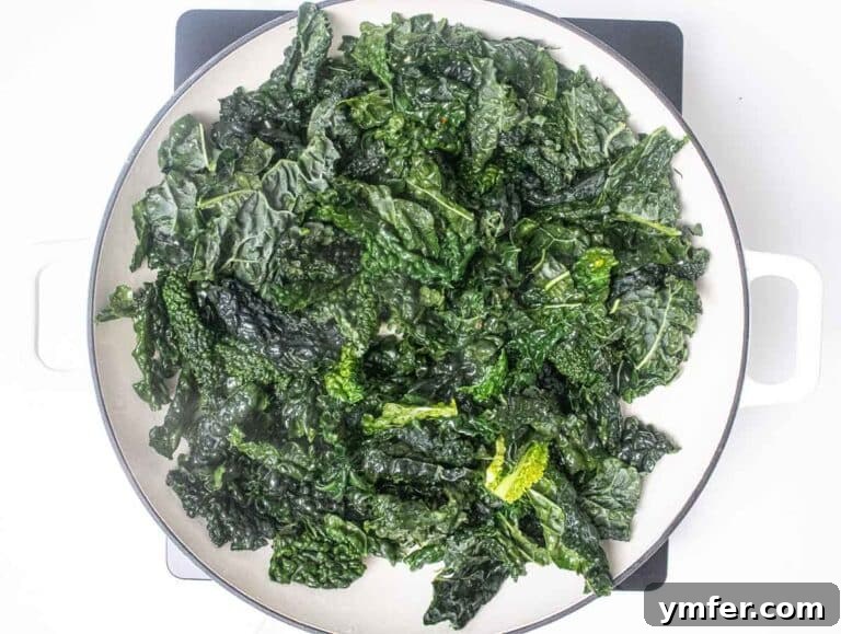 Kale leaves wilting in a skillet with garlic and red pepper flakes