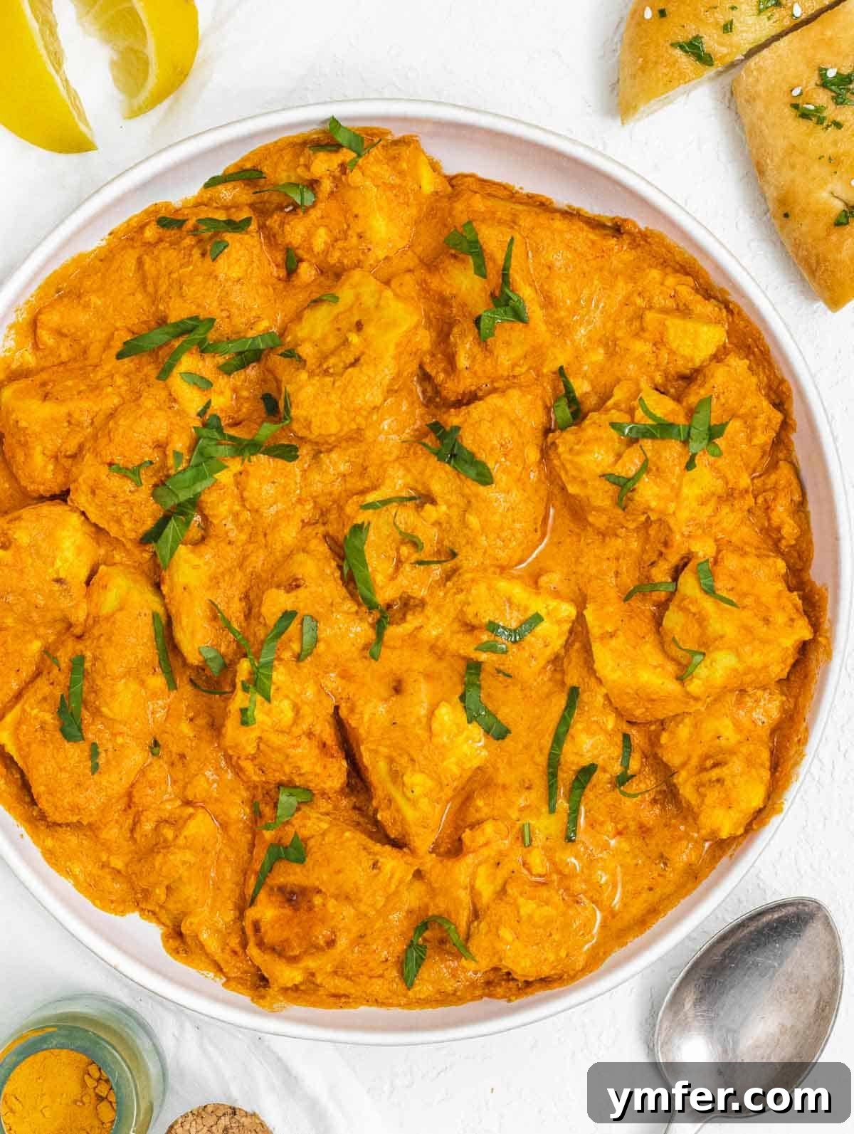 Velvety Vegan Butter Chicken 2 A bowl of creamy Vegan Butter Chicken with tender tofu pieces, garnished with fresh cilantro, ready to be served.