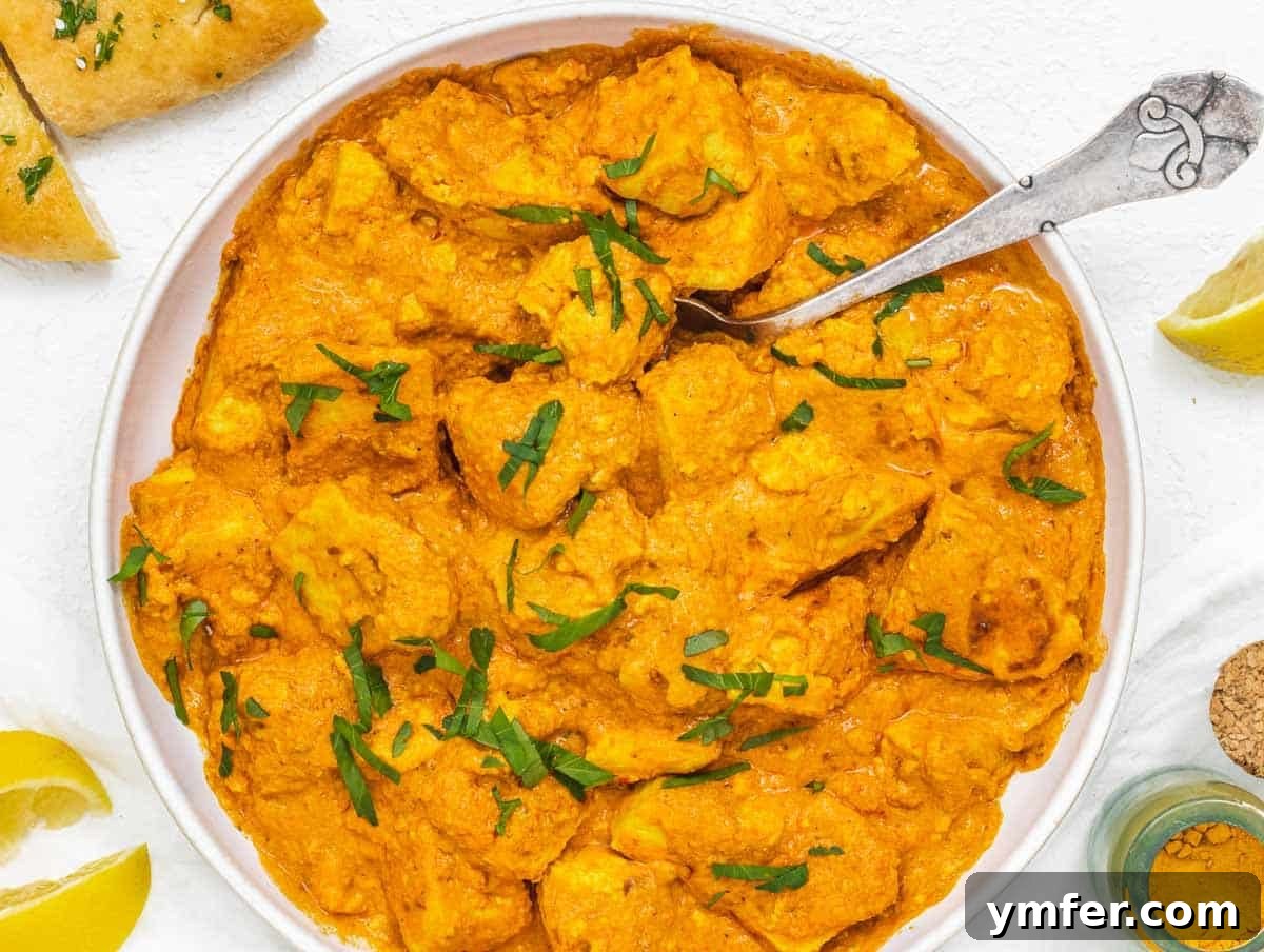 Velvety Vegan Butter Chicken 13 A close-up of creamy vegan butter chicken in a bowl with a spoon, showing its rich texture and appetizing color.