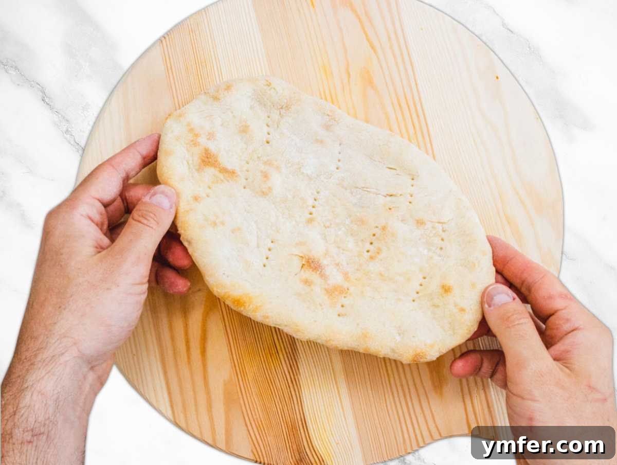 Pillowy Naan 15 Golden brown oven baked naan bread on a baking tray.