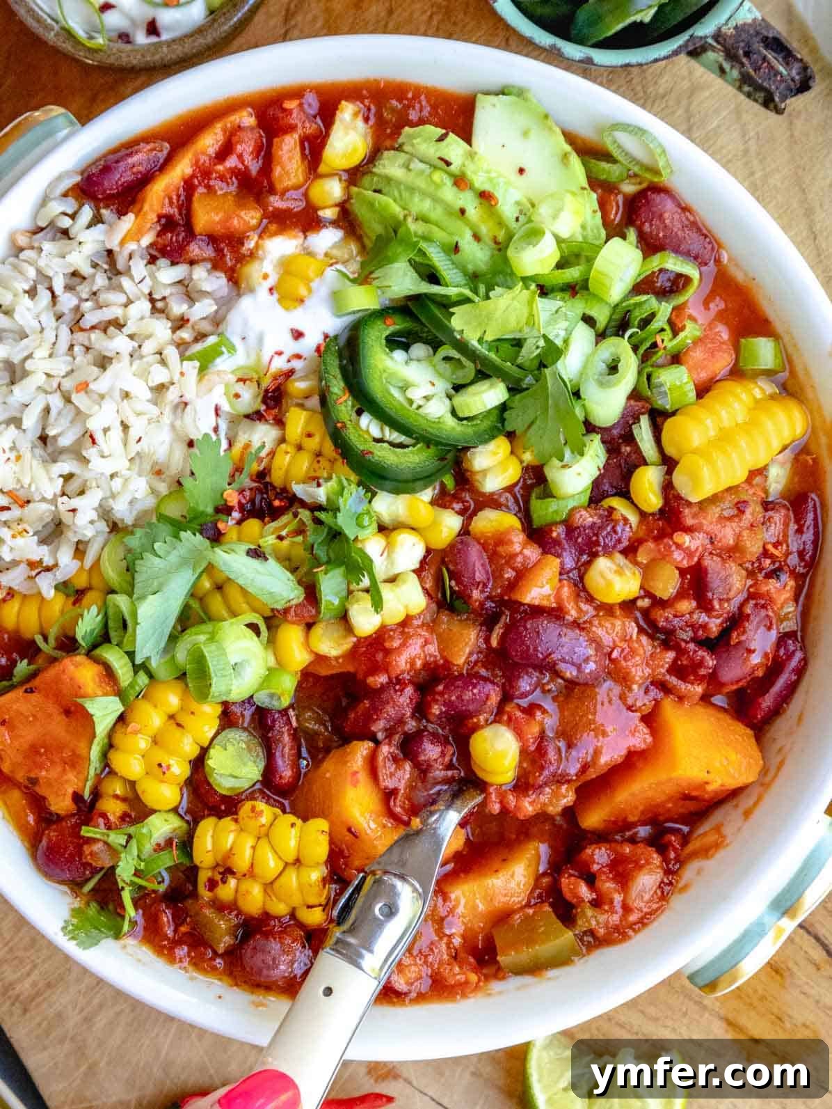 Hearty Sweet Potato Chili 2 sweet potato chili with corn, cilantro, rice and a spoon
