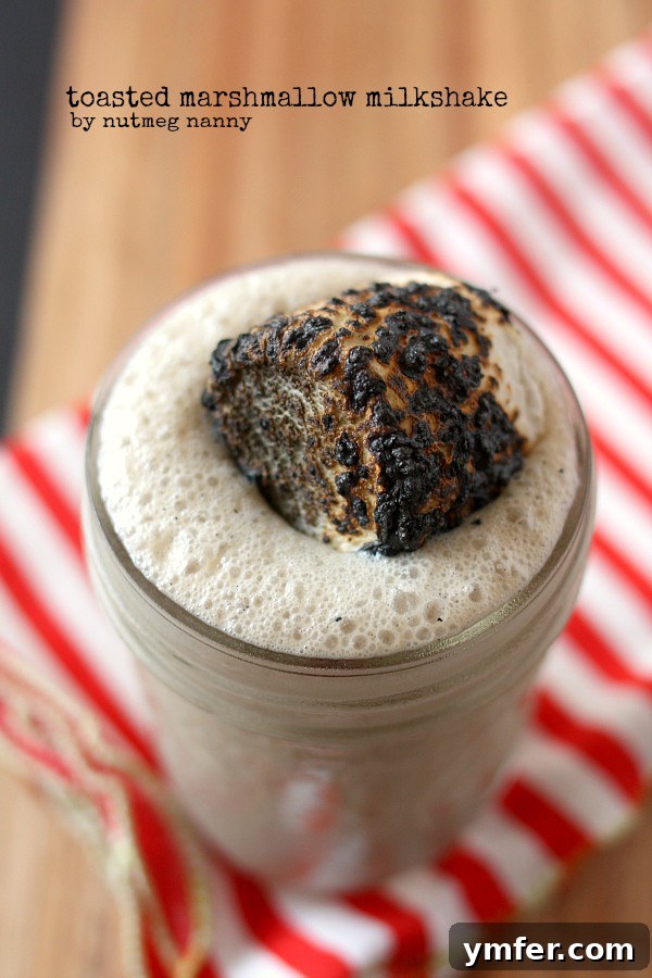 Toasted Marshmallow Milkshake, a delightful frozen treat. Toasted Marshmallow Milkshake in a glass, ready to be enjoyed. A perfect blend of creamy and sweet.