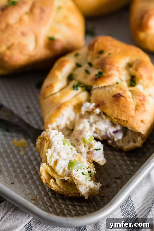 Savory Chicken Crescents 2 Golden-brown Chicken Crescent Packets filled with a creamy chicken, cream cheese, red onion, and celery mixture, ready to eat.