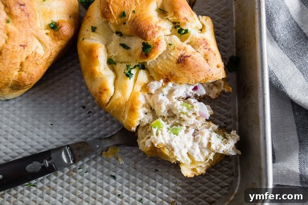 Savory Chicken Crescents 4 Three golden-baked Chicken Crescent Packets arranged on a baking sheet, showcasing their appetizing appearance.