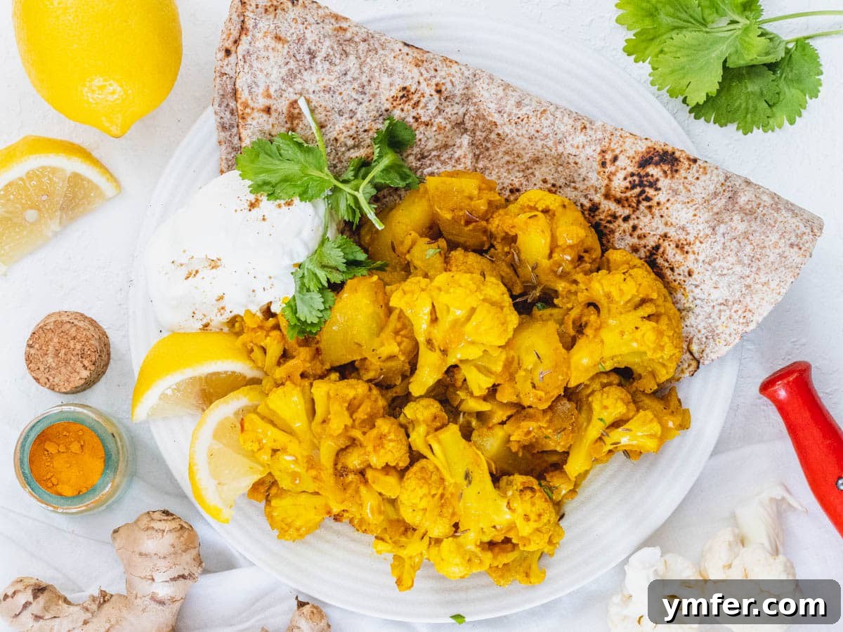 Aloo Gobi served with naan bread and a bowl of yogurt, creating a complete and balanced Indian meal.
