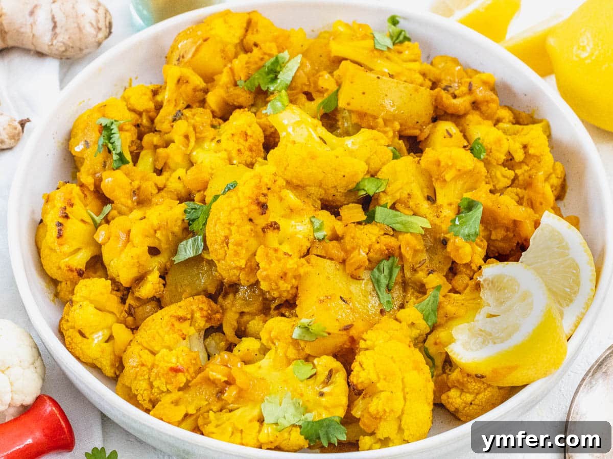 Aloo Gobi in a bowl, garnished with lemon, emphasizing its fresh and wholesome appeal.