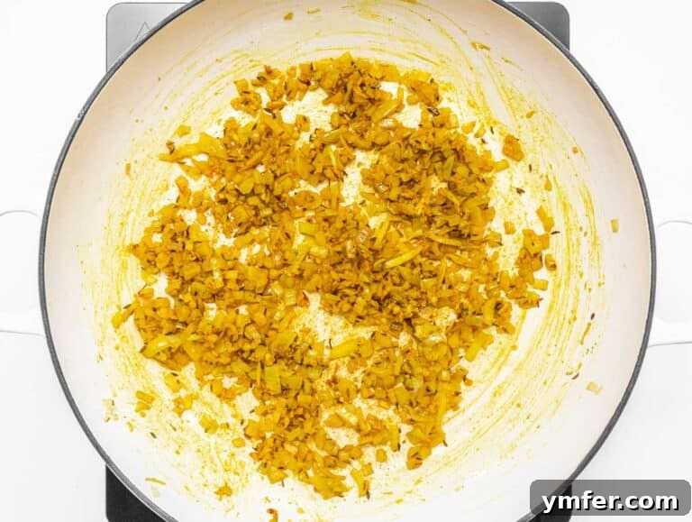 Onions and spices being toasted in a skillet.