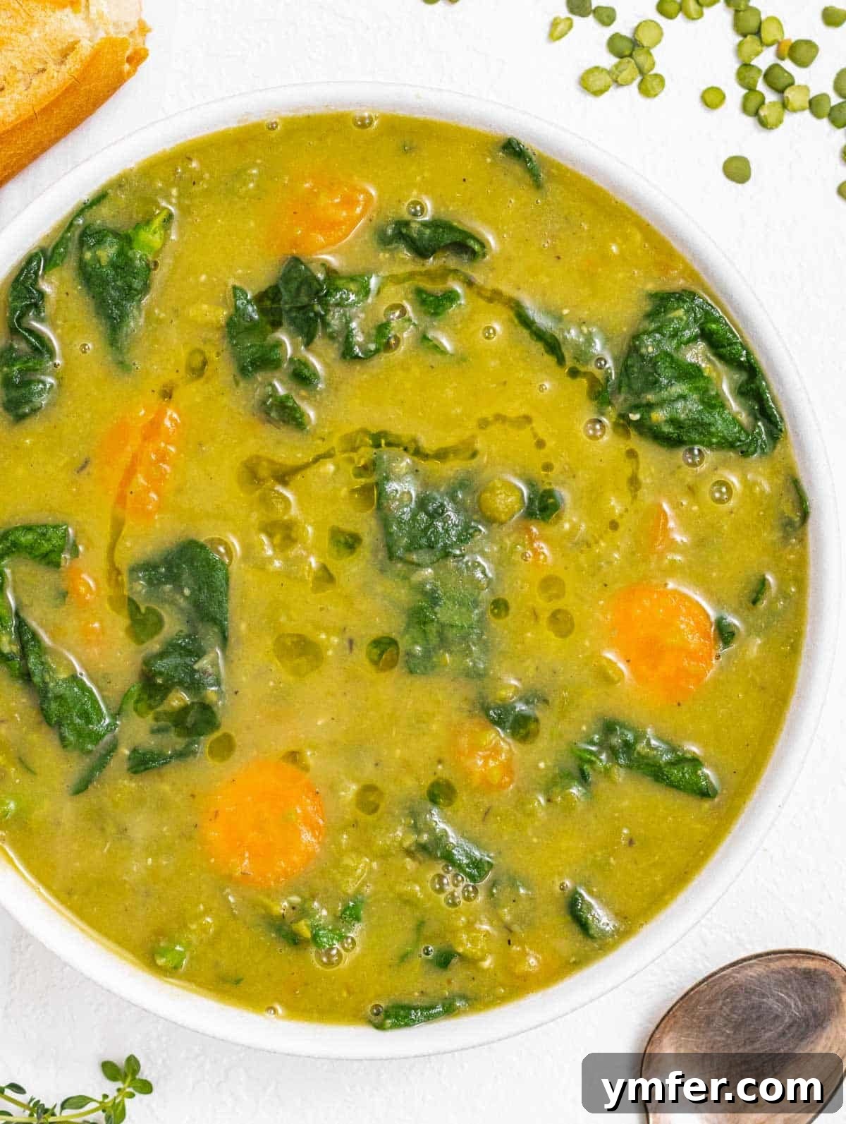 Golden Pea Goodness 2 Delicious bowl of creamy green split pea soup with a slice of fresh baguette on the side, ready to be enjoyed.