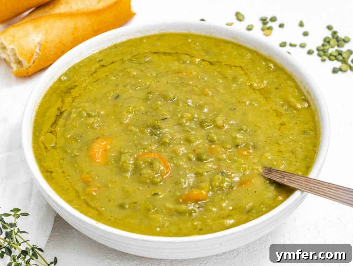 Golden Pea Goodness 13 A silver spoon resting in a bowl of creamy split pea soup, highlighting its rich, thick texture and inviting warmth, perfect for a comforting meal.