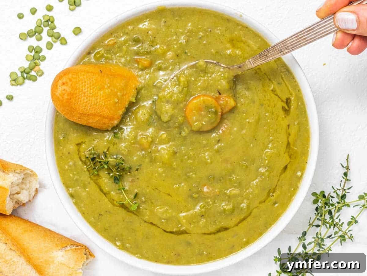 Golden Pea Goodness 3 A hand reaching for a steaming bowl of creamy split pea soup, garnished with fresh herbs and served with a piece of crusty baguette.