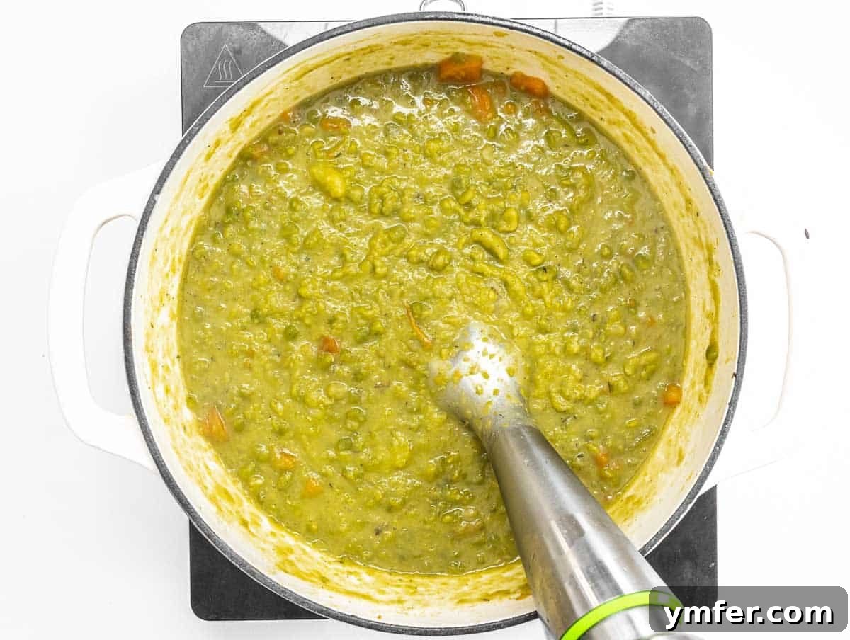Golden Pea Goodness 10 An immersion blender being used to partially blend the split pea soup directly in the pot, creating a beautifully creamy texture.