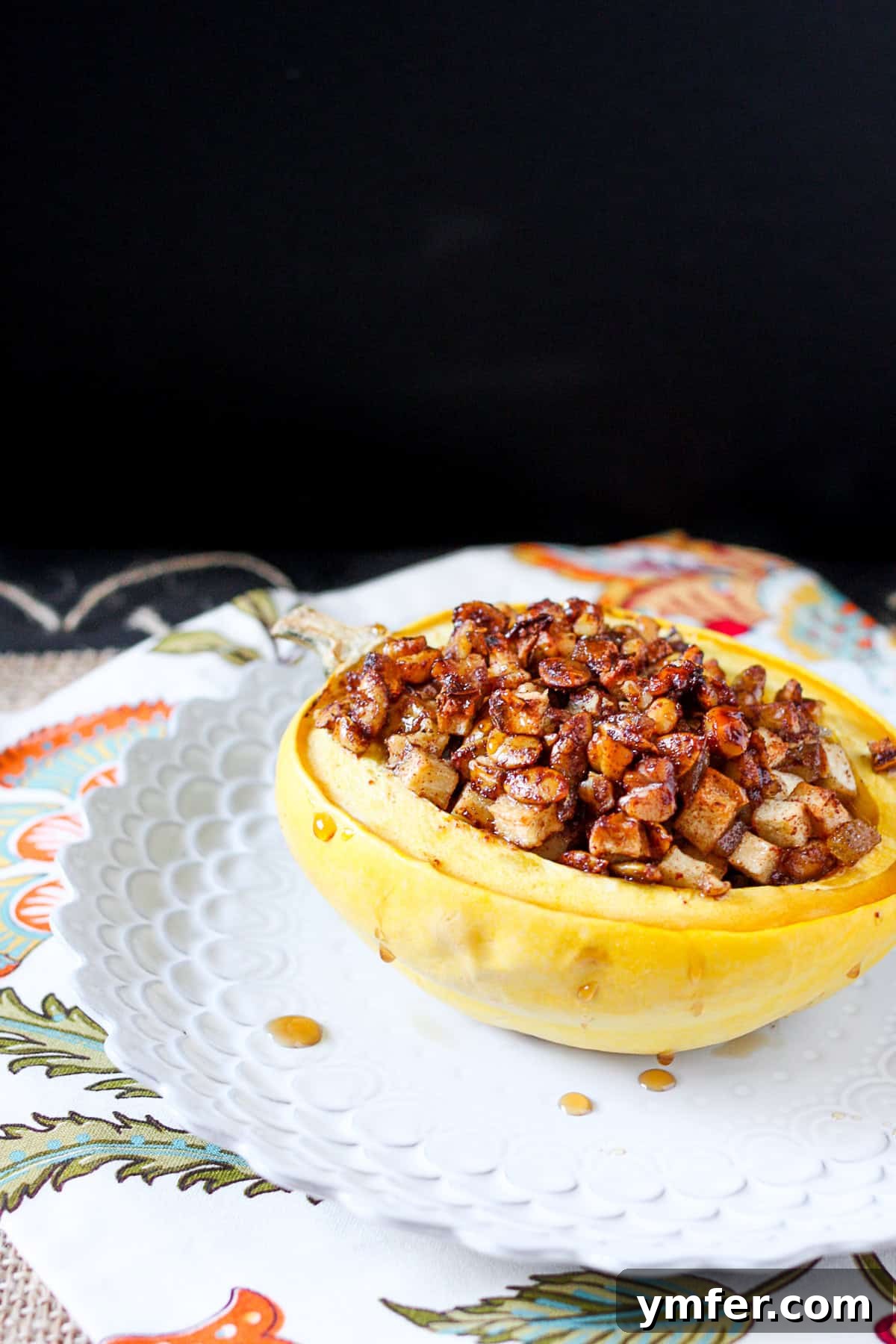 Delicious apple and nut stuffed acorn squash filled with sweet honey crisp apples, pumpkin seeds, walnuts, dried cherries and a touch of maple syrup. A single portion of beautifully roasted Stuffed Acorn Squash, still warm, with a rich, colorful filling. The squash is tender and the topping is golden brown, ready to be enjoyed.