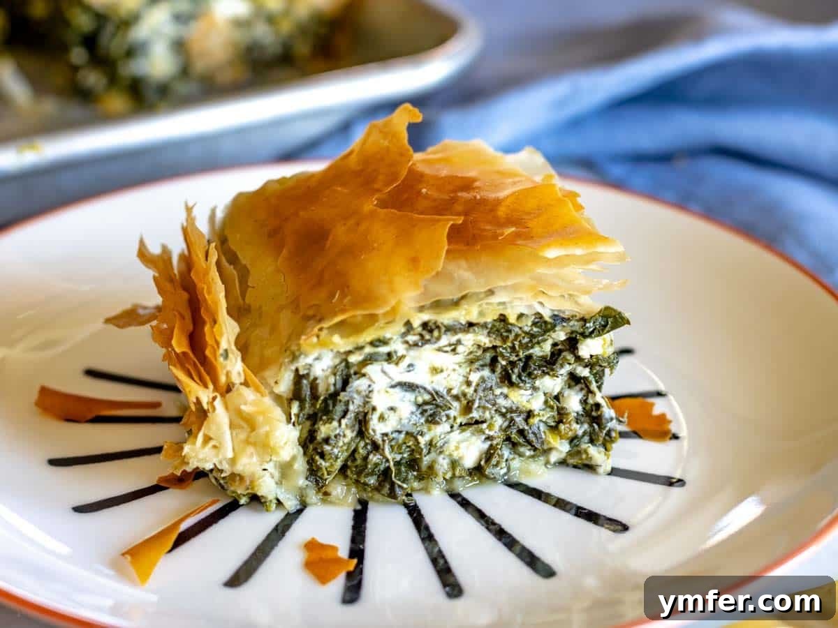 Effortless St Patricks Day Delights 7 A delicious slice of Spanakopita (spinach pie) on a plate.