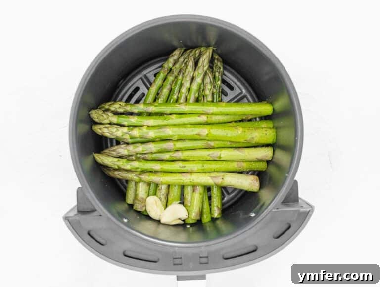 Effortless St Patricks Day Delights 22 Asparagus arranged in an air fryer basket, ready to cook.
