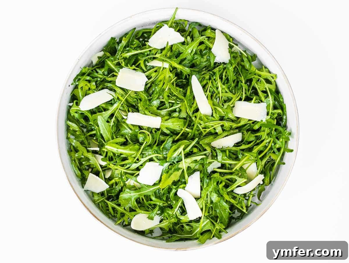 Rucola Rocket Greens with Citrus Vinaigrette 7 Arugula salad with parmesan cheese being added
