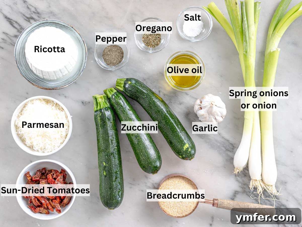 Ingredients for stuffed zucchini laid out on a marble surface, including zucchini, ricotta, sun-dried tomatoes, and herbs.