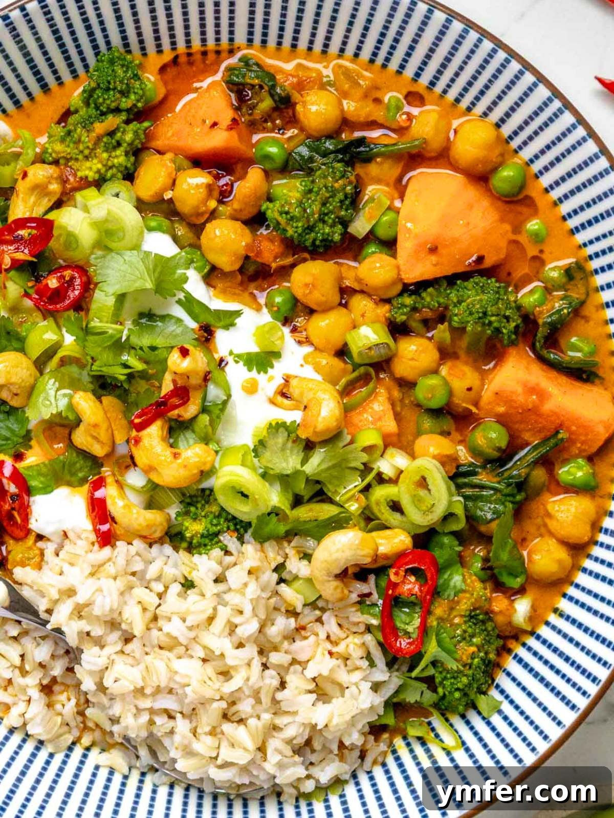 Vibrant Vegetable Curry 2 Vibrant Vegetable Curry served in a bowl, garnished with fresh cilantro and a lime wedge.